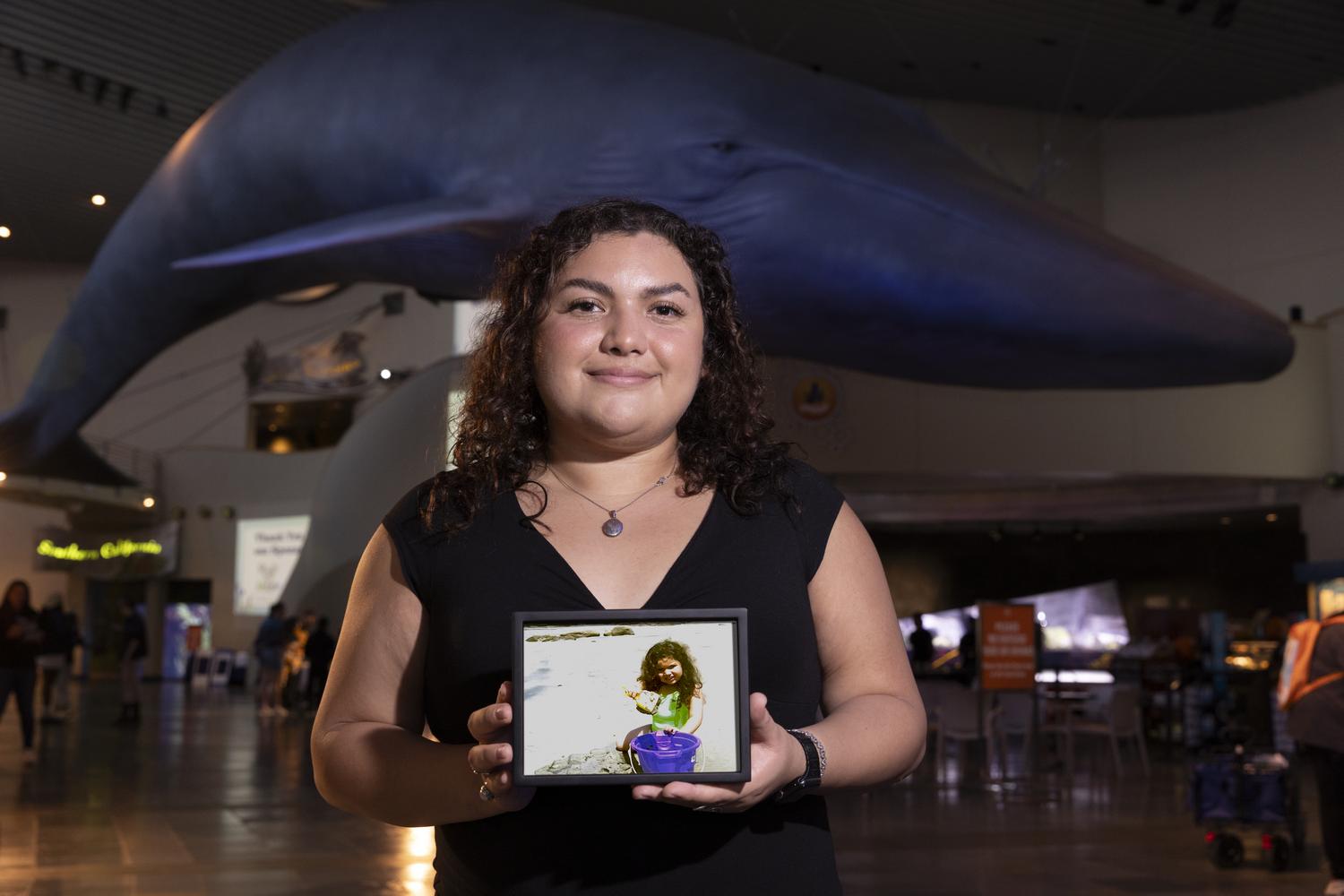 Ivanna holding a framed photo of when they were younger.